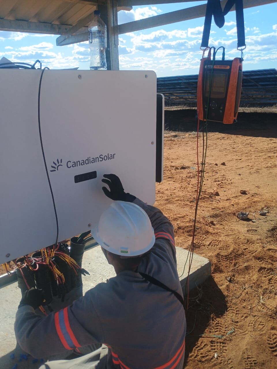 Técnico realizando testes em inversor fotovoltaico Canadian Solar em usina solar